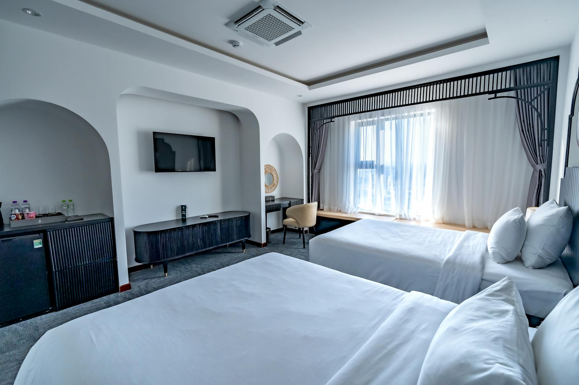Family hotel suite with two double beds and pull-out sofa in a bright room
