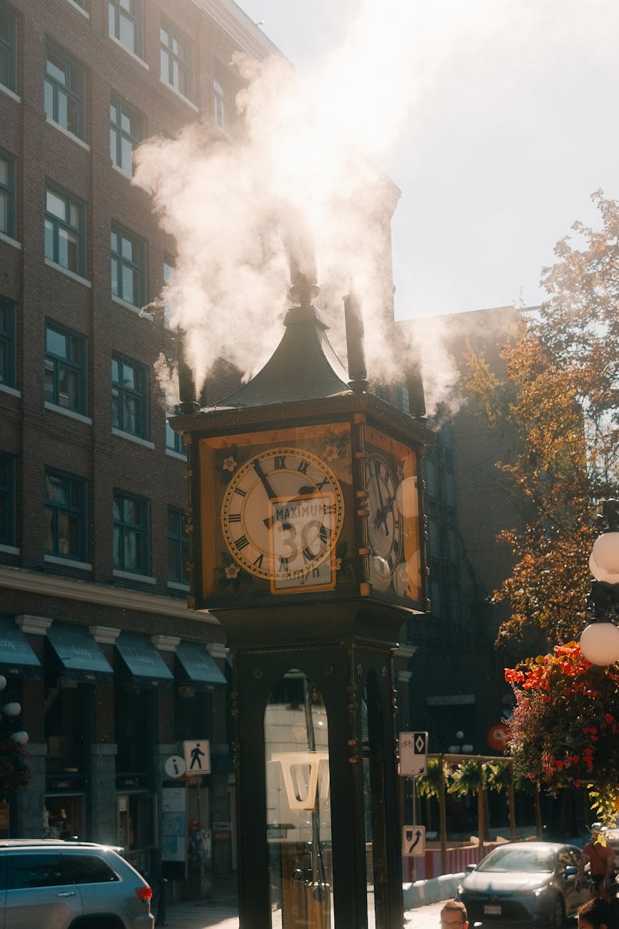 Gastown Steam Clock releasing a white plume of steam on a Vancouver street corner