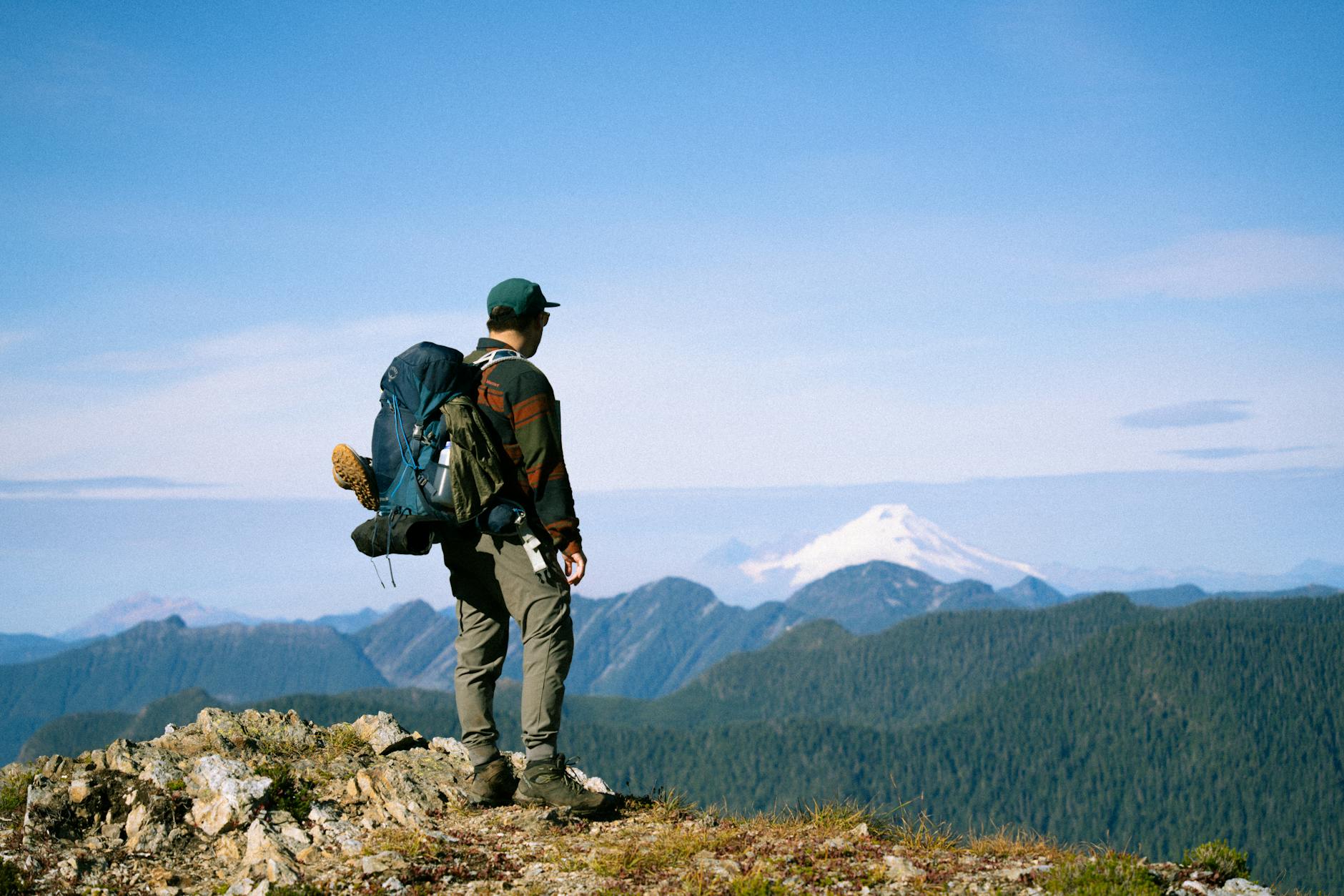 Hiker at alpine summit overlooking Pacific Ocean
