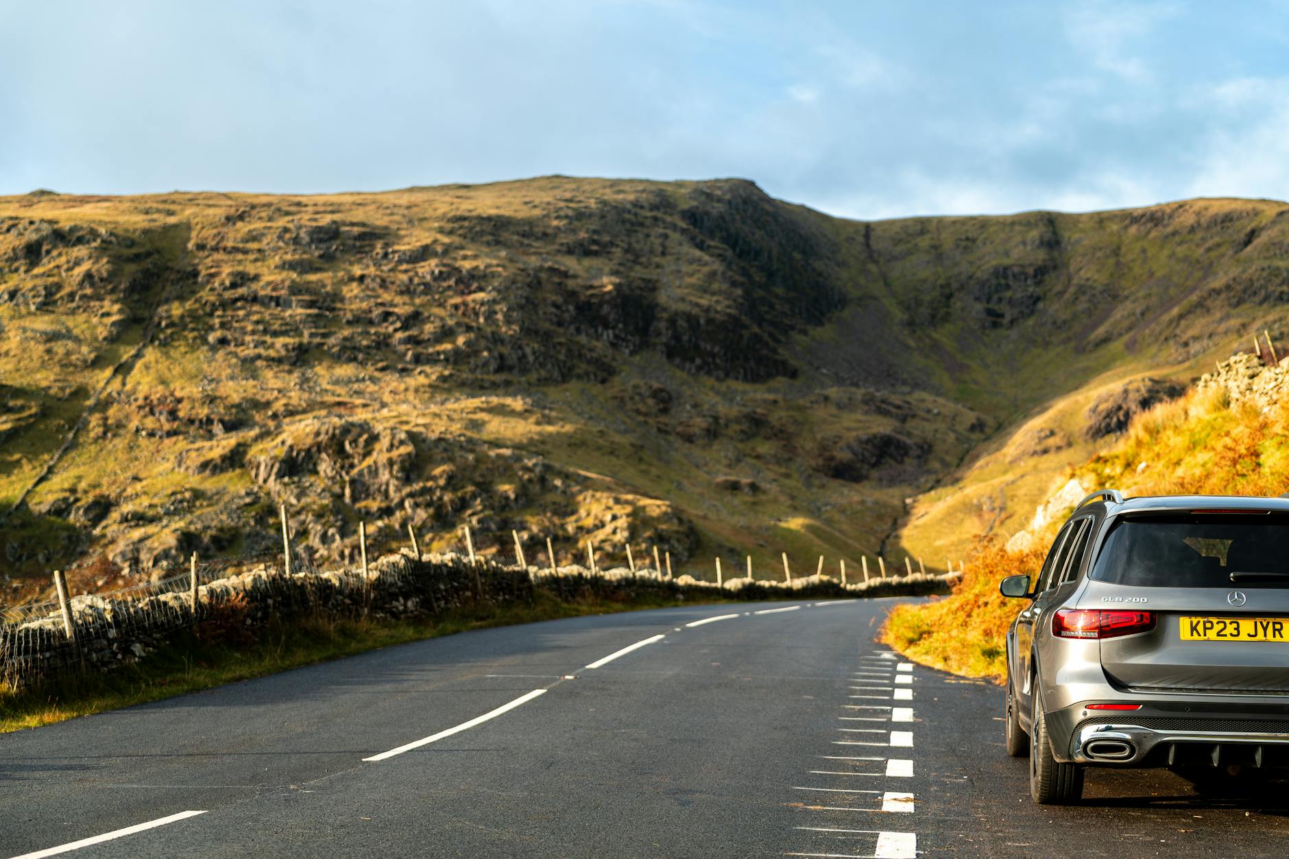 Rental car on an open highway with coastal mountains in the distance