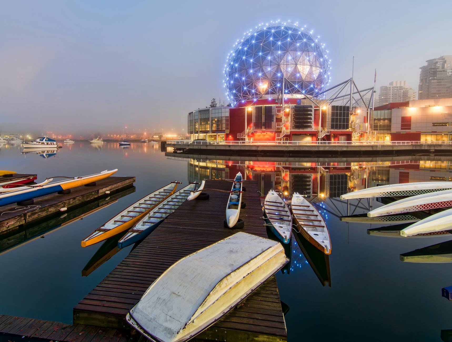 Geodesic dome lit at night by waterfront