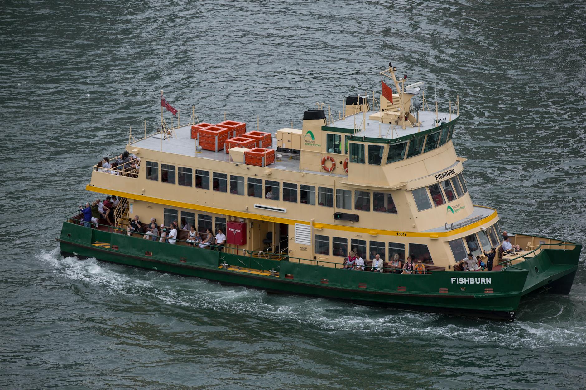 Passenger ferry crossing a busy harbour with city skyline behind