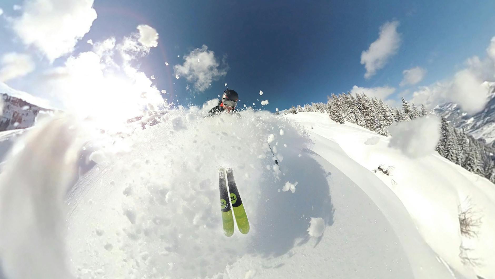 Skier carving through deep powder snow on a mountain run