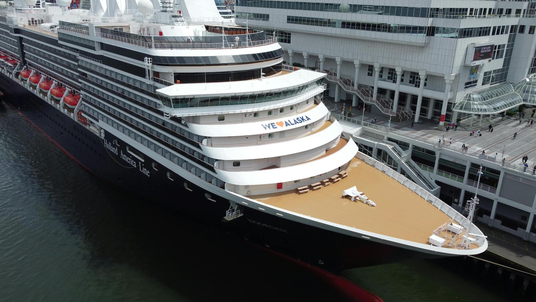 Large Alaska cruise ship at a dock with mountains visible behind