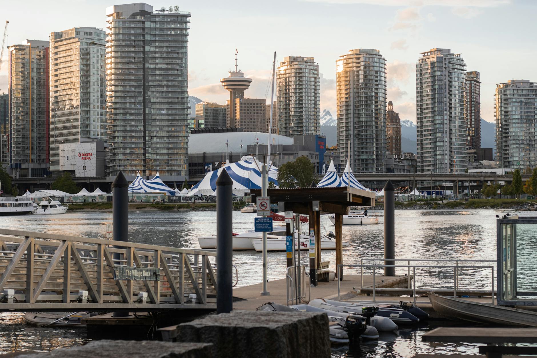 Scenic view of Vancouver's skyline reflecting on water during golden hour, captured from Village Dock.