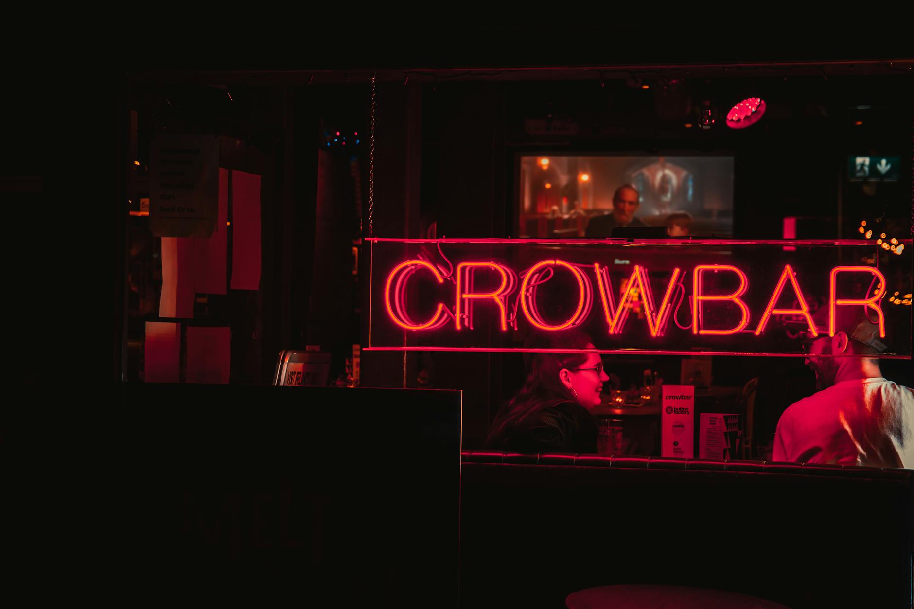 Two people enjoying a lively night at a Granville Street club with vibrant neon lights.