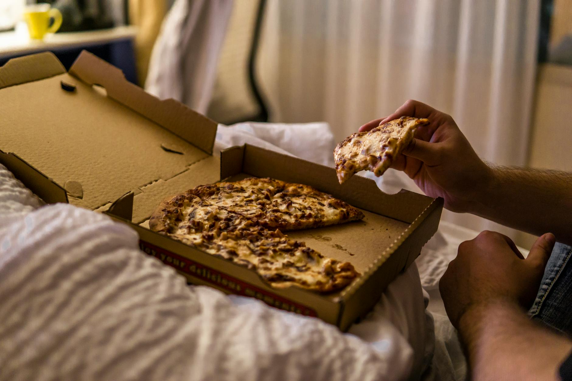 A late-night pizza counter with slices under warming lights.