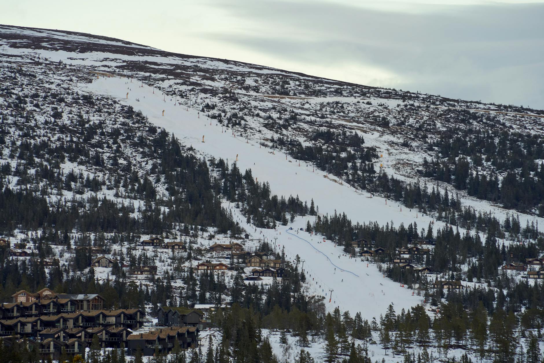Skiers on a snowy slope above Vancouver with the city visible below.