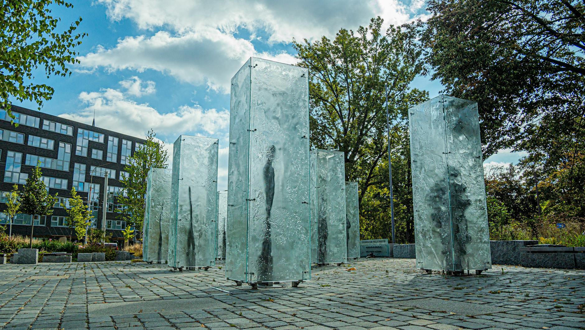 A large outdoor sculpture on a Vancouver plaza with the city behind it.