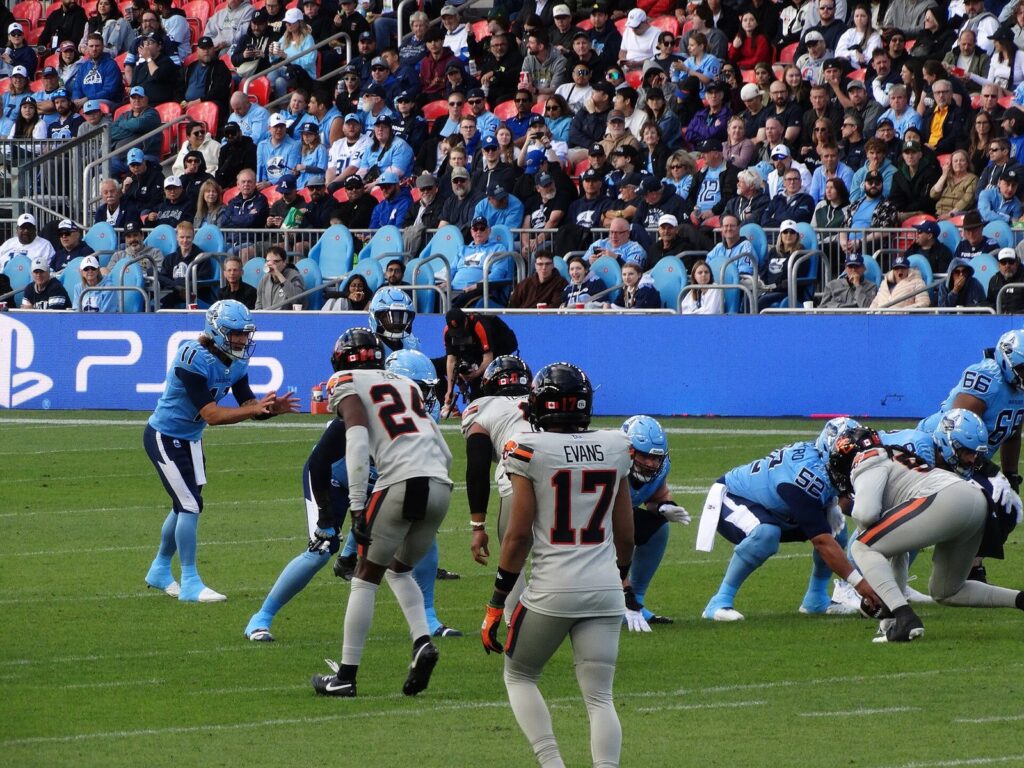 BC Lions players in white and orange lined up against the Toronto Argonauts before a snap