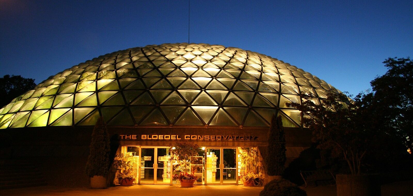 The glass dome of the Bloedel Conservatory glowing at dusk at the top of Queen Elizabeth Park