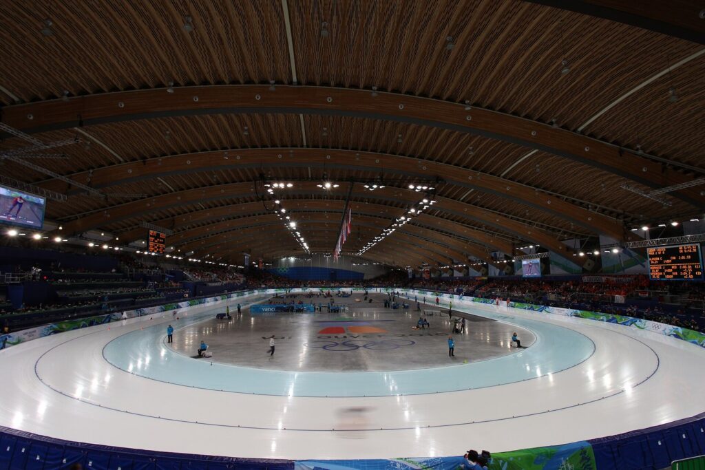 Speed skaters racing on the long-track oval under the curved wooden roof of the Richmond Olympic Oval