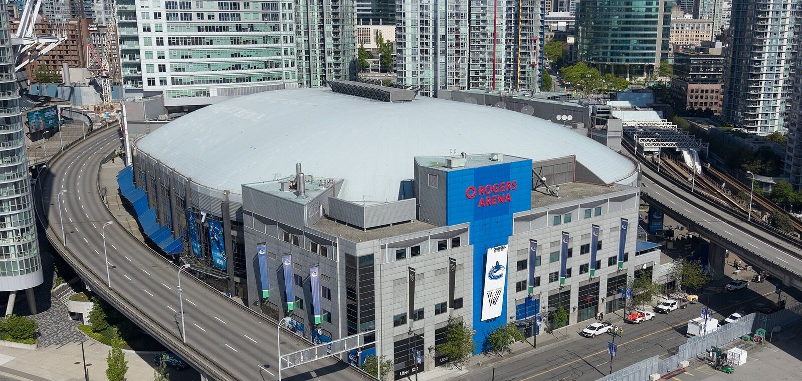 Aerial view of Rogers Arena with its red sign and Canucks banners beside the Georgia Viaduct