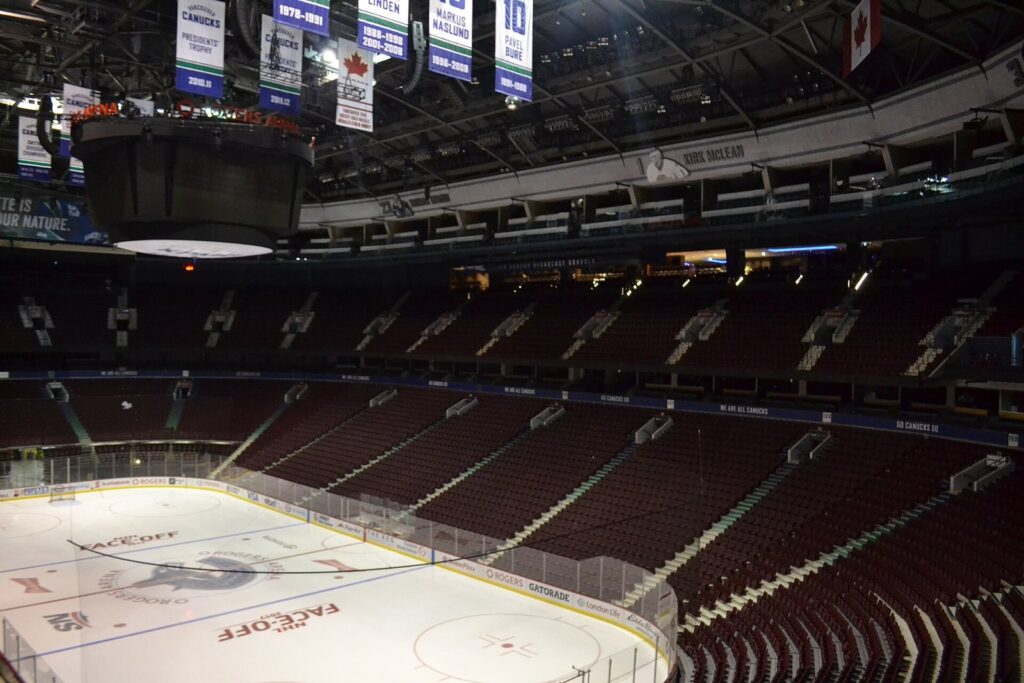 Empty lower and upper bowls of Rogers Arena around the ice under the scoreboard