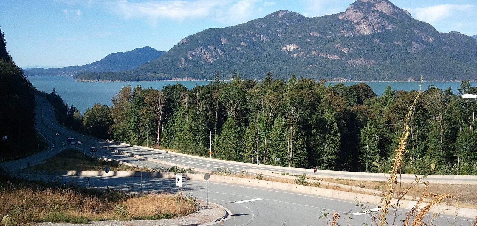 Sea to Sky Highway curving along Howe Sound near Porteau Cove with a mountain rising from the water
