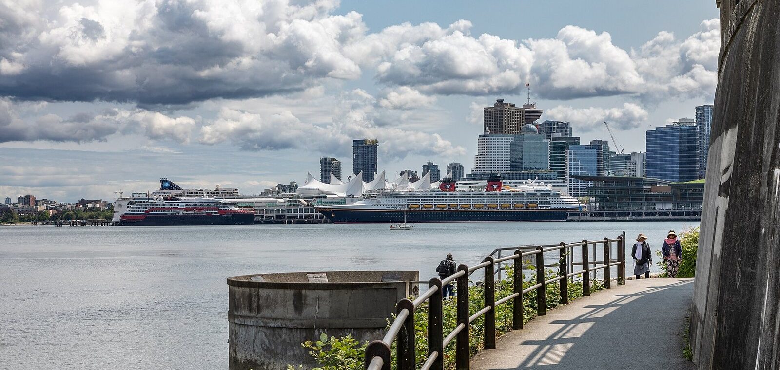 Stanley Park Seawall path curving toward Canada Place, docked cruise ships and the downtown skyline