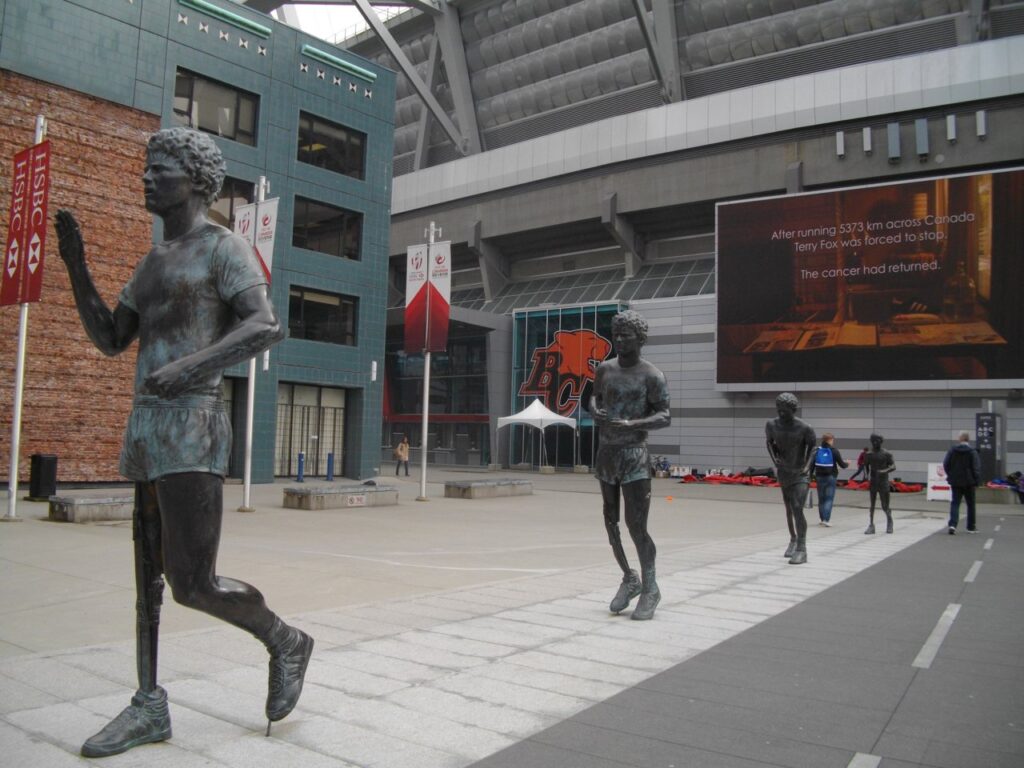 Bronze statues of Terry Fox running along Terry Fox Plaza beside BC Place