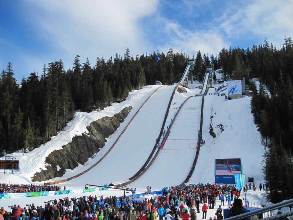 The two ski jumps at Whistler Olympic Park rising above a crowd of spectators in 2010